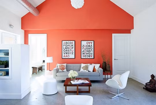 Phòng khách hiện đại hơn với bức tường màu cam san hô nổi bật trên nền trắng.