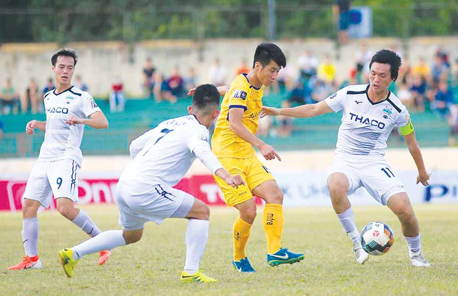  Cầu thủ HAGL (áo trắng) gặp SLNA (áo vàng) trong trận lượt đi mùa giải năm nay. Ảnh: H.T
