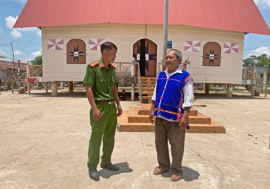 Ông Đinh Văn Chiêm trao đổi thông tin với cán bộ Công an xã Yang Nam, huyện Kông Chro. Ảnh: R’Ô HOK