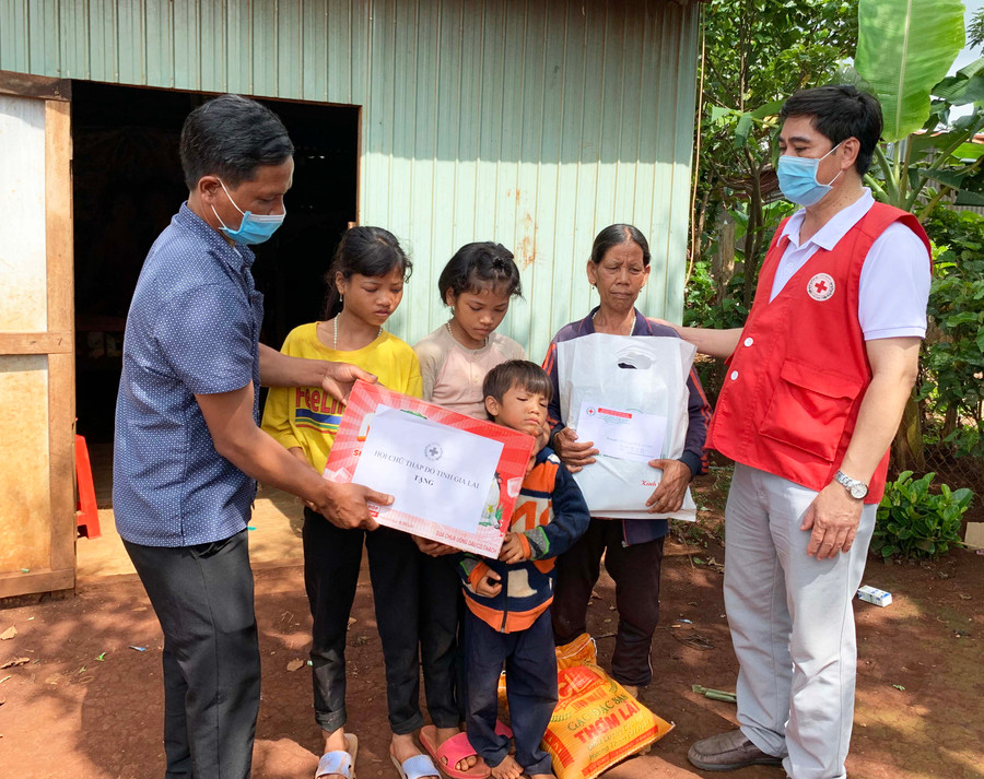 Ông Cao Xuân Nam- Phó Chủ tịch Hội Chữ thập đỏ tỉnh (áo đỏ) trao quà cho gia đình bà Dúch. ẢNh: Như Nguyện