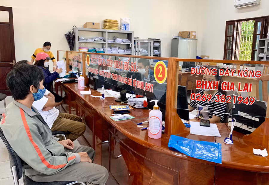 Cán bộ BHXH tỉnh hướng dẫn người dân các thủ tục liên quan chính sách BHXH, bảo hiểm y tế. Ảnh: Như Nguyện