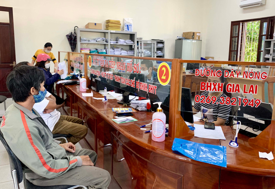 Cán bộ BHXH tỉnh hướng dẫn người dân các thủ tục liên quan chính sách BHXH, bảo hiểm y tế. Ảnh: Như Nguyện