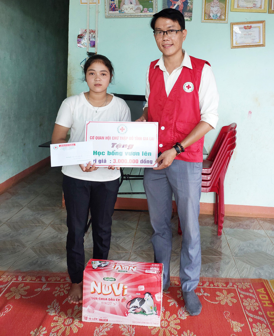 Trao học bổng và sữa cho em Rơ Châm Chol-học sinh lớp 9 Trường Tiểu học và THCS Nghĩa Hòa, Chư Păh. Ảnh: Hồng Ngọc