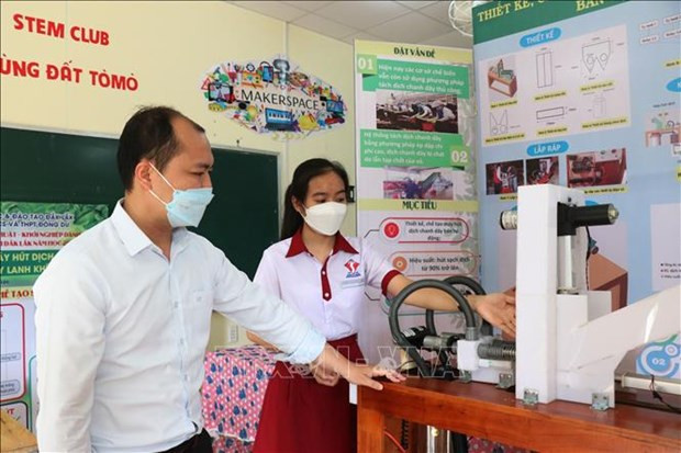 Em Vi Thị Thu Hà giới thiệu máy hút dịch chanh dây bán tự động. Ảnh: Tuấn Anh-TTXVN