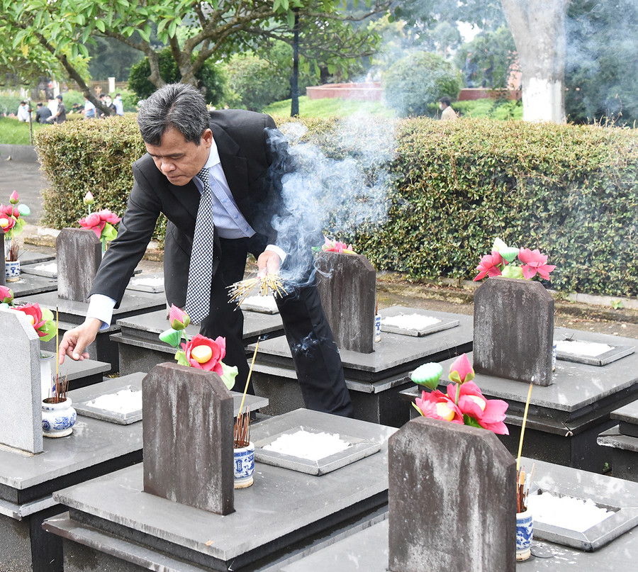 Bí thư Tỉnh ủy Hồ Văn Niên thắp hương lên các phần mộ liệt sĩ tại Nghĩa trang Liệt sĩ tỉnh. Ảnh: Đức Thụy