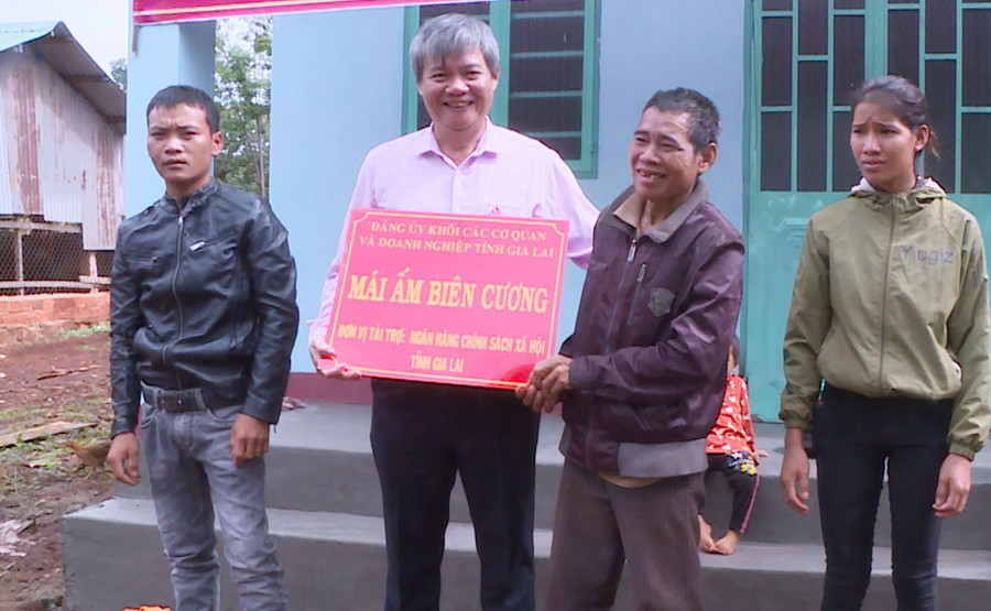 Đại diện Chi ủy-Chi bộ Ngân hàng Chính sách Xã hội tỉnh Gia Lai trao tiền tài trợ cho gia đình ông Rơ Mah Bác (làng Lang, xã Ia Chía, huyện Ia Grai). Ảnh: Phương Lộc