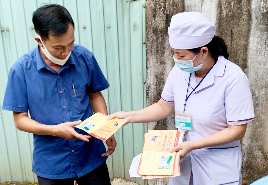 Nhân viên y tế phường Phù Đổng (TP. Pleiku) phát tờ rơi tuyên truyền phòng-chống sốt xuất huyết cho người dân trên địa bàn. Ảnh: Như Nguyện