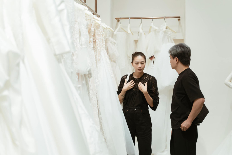  Ngô Thanh Vân bàn bạc rất kỹ với chuyên gia trang điểm Nam Trung để tìm ra chiếc váy cưới ưng ý nhất. Ảnh: FBNV