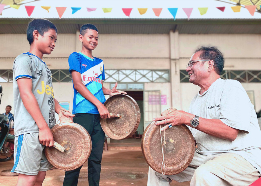 Em Jang (ở giữa, làng Ngó, phường Trà Bá) tập đánh cồng chiêng dưới sự hướng dẫn của nghệ nhân Ksor Hnao. Ảnh: Mộc Trà