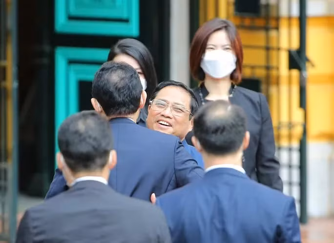 Thủ tướng Phạm Minh Chính đón Thủ tướng Nhật Bản Kishida Fumio tại cửa xe ôtô. Ảnh: Hữu Hưng