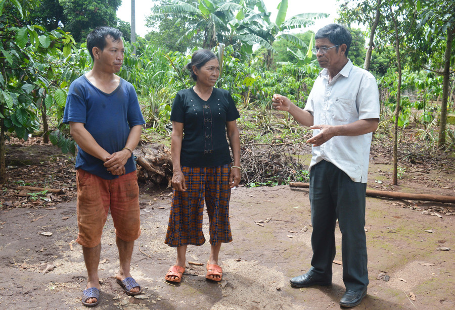 Ông Rơ Châm Haih (bìa phải) tuyên truyền, vận động người dân làng Or đẩy lùi hủ tục. Ảnh: Phương Dung