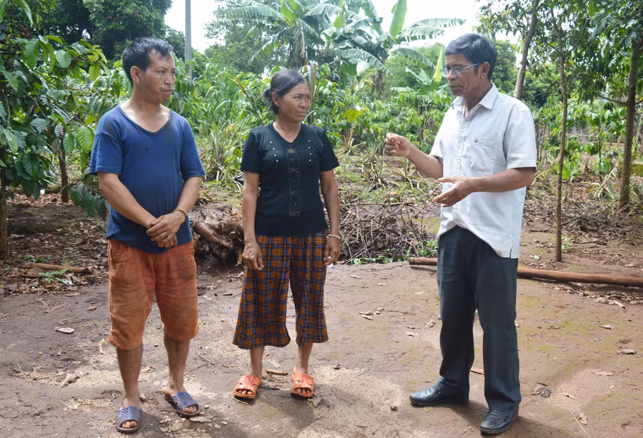 Ông Rơ Châm Haih (bìa phải) tuyên truyền, vận động người dân làng Or đẩy lùi hủ tục. Ảnh: Phương Dung