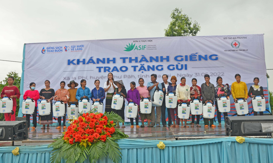 Hoa hậu H’Hen Niê(thứ 7 từ trái sang)-đại sứ Nhân ái của tổ chức ASIF trao tặng gùi nước cho bà con. Ảnh: Hoàng Cư