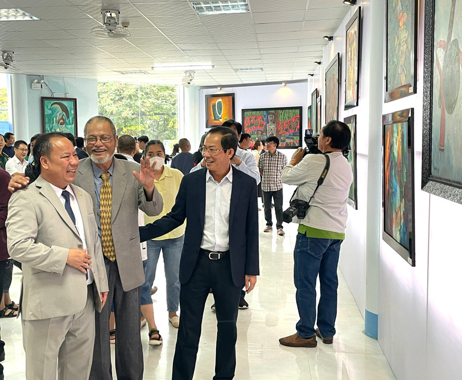 Phó Bí thư Thường trực Tỉnh ủy Châu Ngọc Tuấn (bìa trái) và Phó Chủ tịch Thường trực UBND Đỗ Tiến Đông (thứ 3 từ trái sang) chia sẻ niềm vui cùng họa sĩ Lê Hùng. Ảnh: Phương Duyên