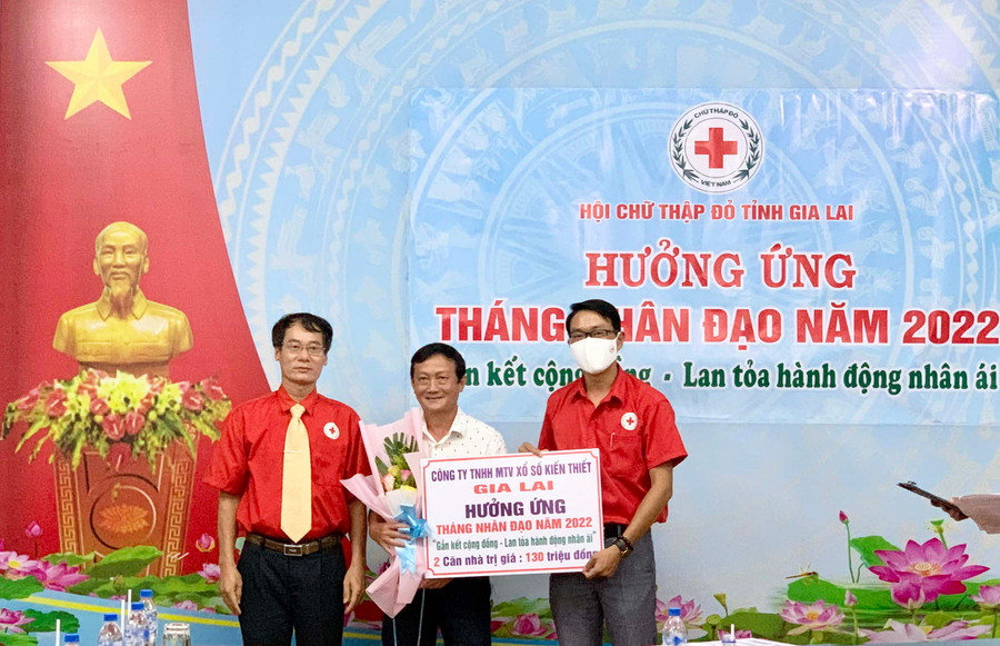 Đại diện Công ty TNHH MTV Xổ số kiến thiết tỉnh Gia Lai (giữa) trao bảng đăng ký tài trợ 2 căn nhà trị giá 130.000.000 đồng trong Tháng Nhân đạo 2022. Ảnh: Như Nguyện 