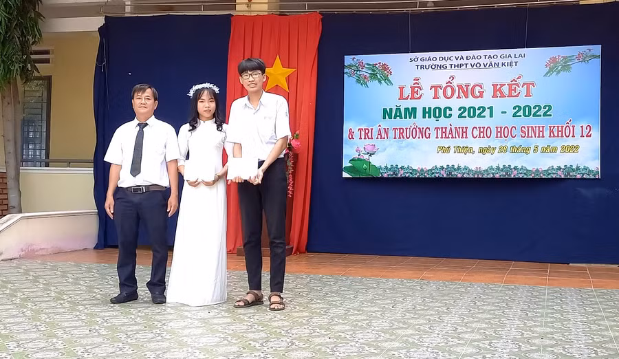 Thầy Sơn-đại diện Quỹ trao học bổng cho 2 em học sinh trường THPT Võ Văn Kiệt. Ảnh: Anh Huy