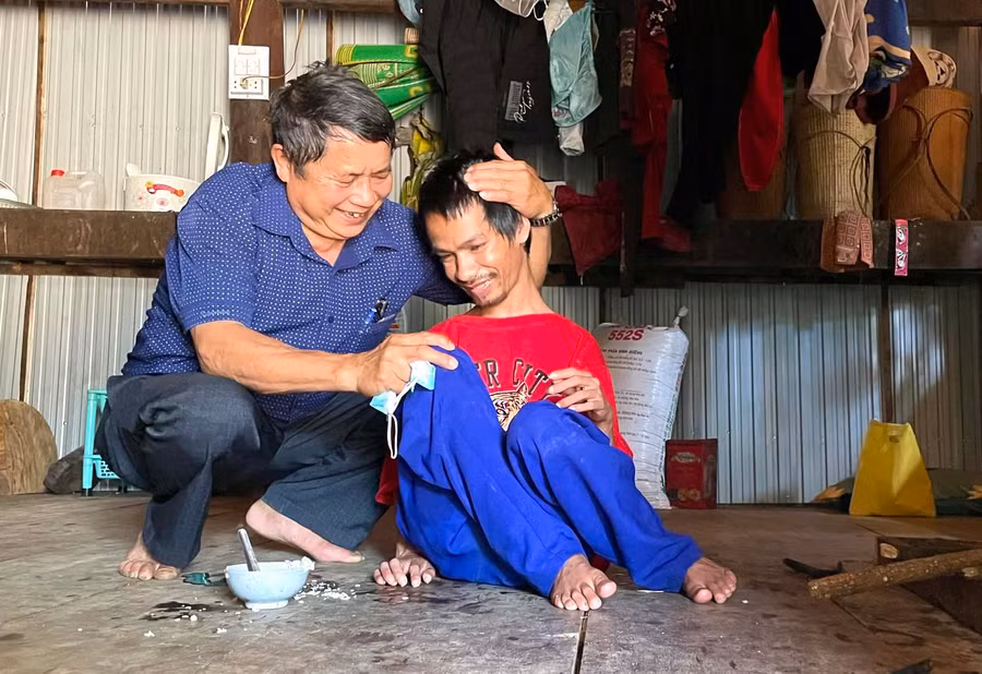 Ông Chu Văn Định-Chủ tịch Hội NNCĐDC/dioxin huyện Kbang thăm hỏi em Đinh Văn Thân (làng Nak, thị trấn Kbang) bị nhiễm chất độc da cam. Ảnh: Minh Phương