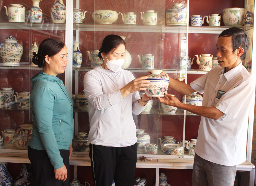 Anh Lê Tấn Khoang giới thiệu thông tin cổ vật cho người dân đến tham quan. Ảnh: Minh Nhật