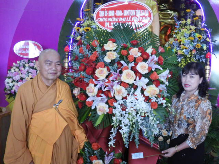 Phó Chủ tịch Thường trực Ủy ban MTTQ Việt Nam tỉnh Phạm Thị Lan (bìa phải) trao lẵng hoa của Tỉnh ủy, HĐND, UBND, Ủy ban MTTQ Việt Nam tỉnh chúc mừng Đại lễ Phật đản. Ảnh: Thanh Nhật