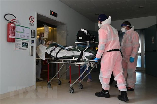 Nhân viên y tế chuyển bệnh nhân COVID-19 vào bệnh viện ở Cremona, Italy. 