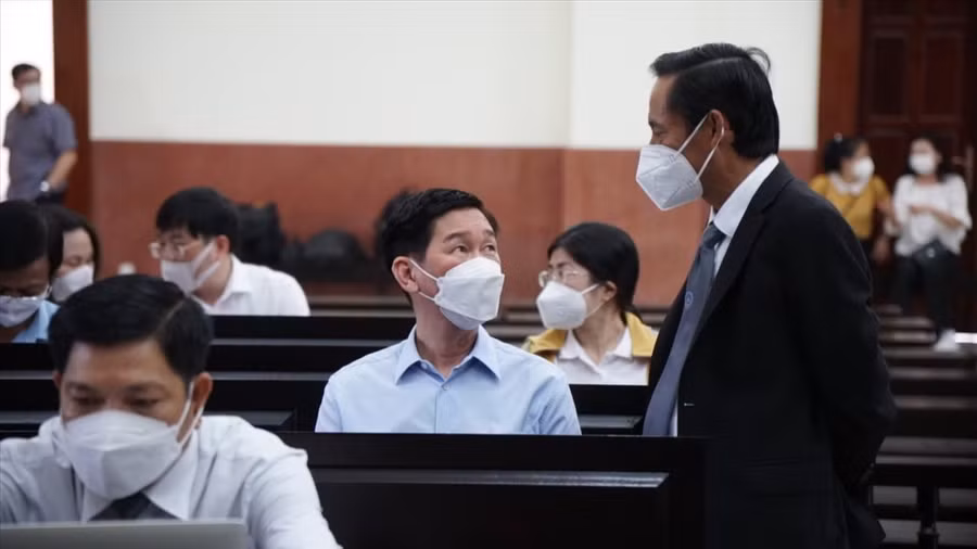 Bị cáo Trần Vĩnh Tuyến đang trao đổi luật sư bào chữa của mình tại phiên toà phúc thẩm.