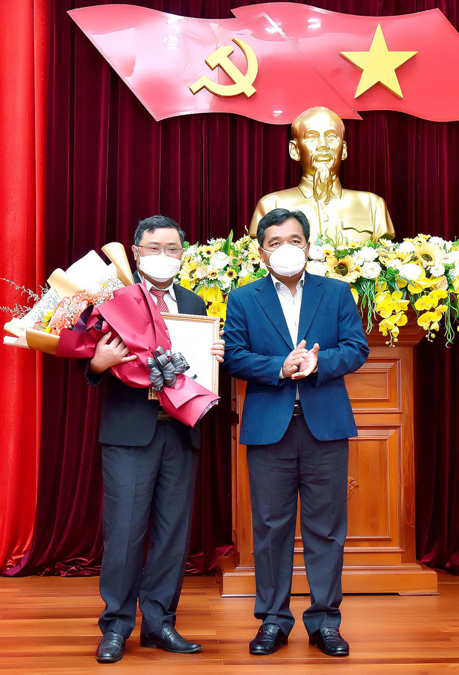 Đồng chí Hồ Văn Niên (bìa phải)-Ủy viên Ban Chấp hành Trung ương Đảng, Bí thư Tỉnh ủy, Chủ tịch HĐND tỉnh trao quyết định và tặng hoa chúc mừng Phó Chủ nhiệm Ủy ban Kiểm tra Tỉnh ủy Phan Quang Thái. Ảnh: Đức Thụy