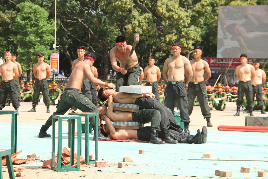 Nhiều chiến sĩ cảnh sát cơ động biểu diễn khí công nằm trên tấm đinh nhọn. Ảnh: Hoàng Bình