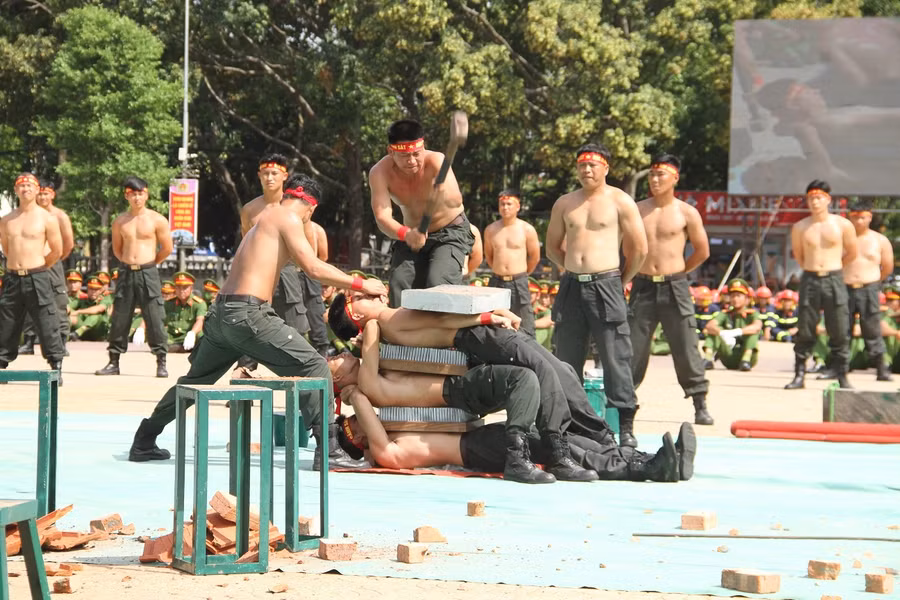 Nhiều chiến sĩ cảnh sát cơ động biểu diễn khí công nằm trên tấm đinh nhọn. Ảnh: Hoàng Bình