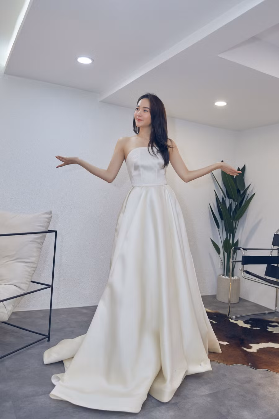 Nữ ca sĩ thả dáng trong chiếc váy cưới tại studio. Thiết kế cúp ngực đơn giản giúp cô dâu tương lai khoe trọn bờ vai gợi cảm. Ảnh: NVCC