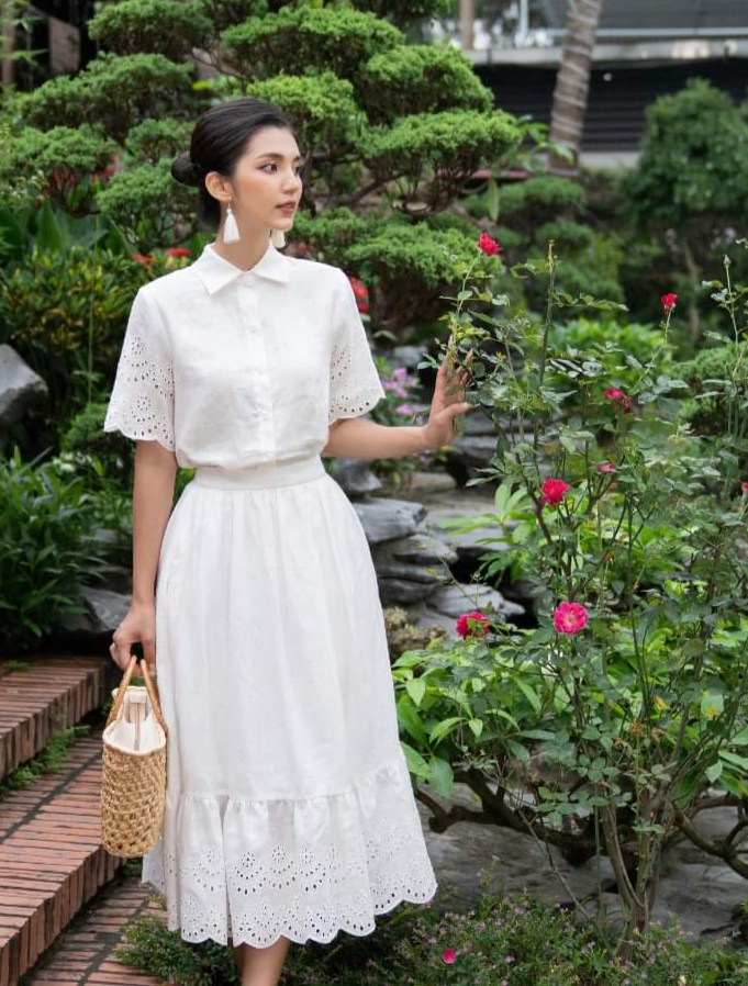 Những kiểu áo sơ mi tay đục lỗ có thể mix với chân váy cùng tone mang đến sự dịu dàng, điệu đà cho set đồ ngày nắng.