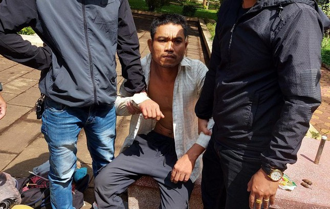 Đối tượng Y Tơng (áo trắng) thời điểm bị bắt giữ và được dẫn giải đến hiện trường vụ án gây rúng động dư luận. Ảnh: Uy Nguyễn.