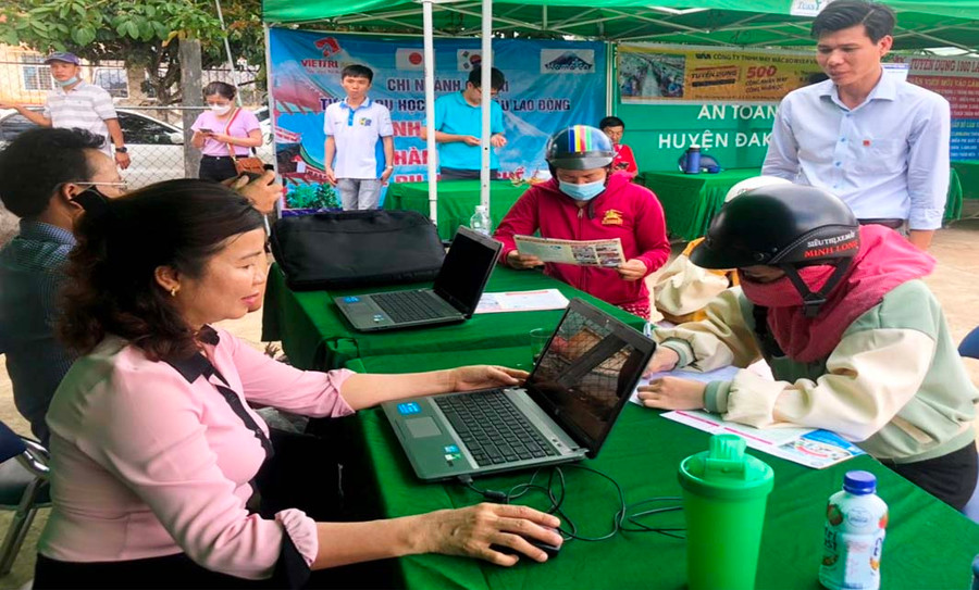 Cán bộ Trung tâm Dịch vụ việc làm tư vấn tỉnh tư vấn việc làm cho lao động đến tham gia phiên giao dịch việc làm lồng ghép tại phiên chợ nông sản an toàn. Ảnh: Đinh Yến