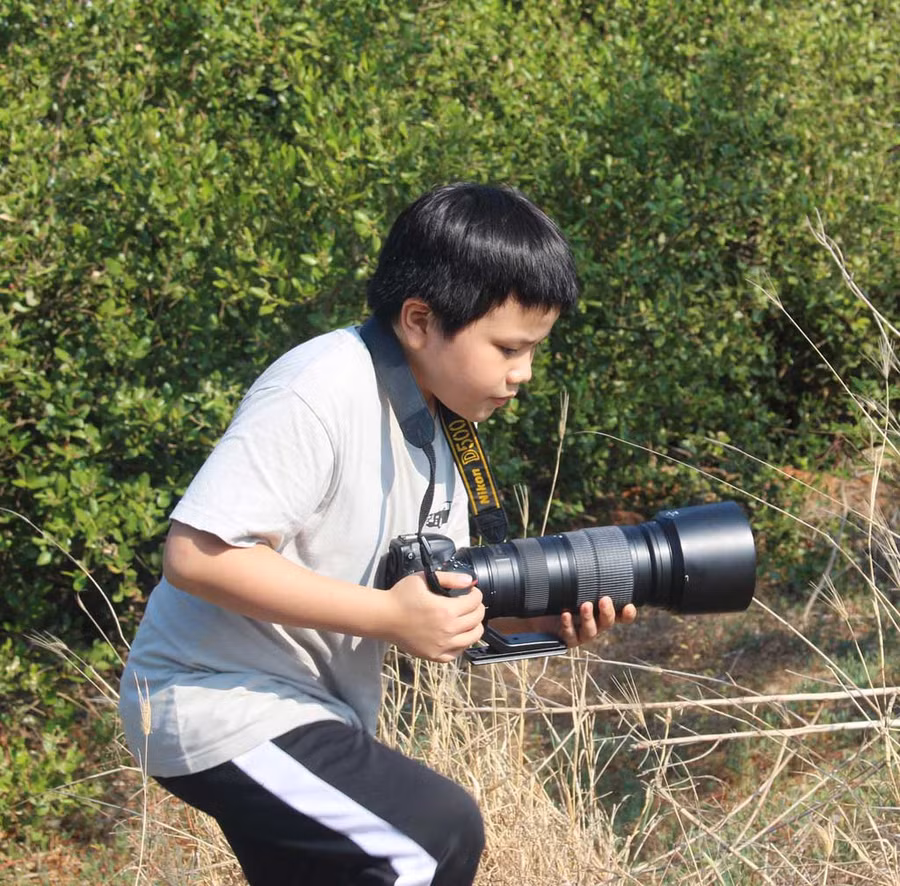 Bé Duy Nhiên bất chấp gian khổ để đi chụp chim hoang dã. Ảnh: NVCC