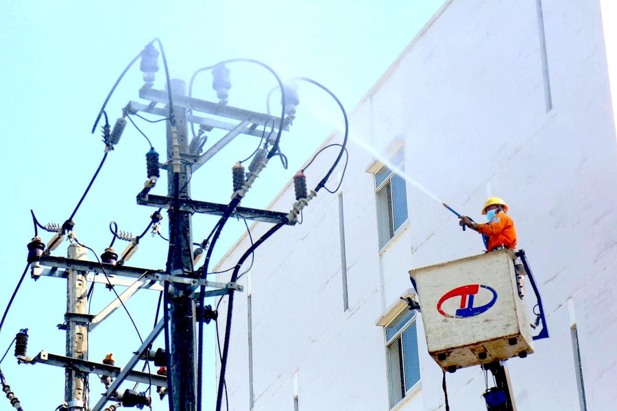 Ngành điện thực hiên vệ sinh sứ bằng công nghệ hotline. Ảnh: Khang Nghi