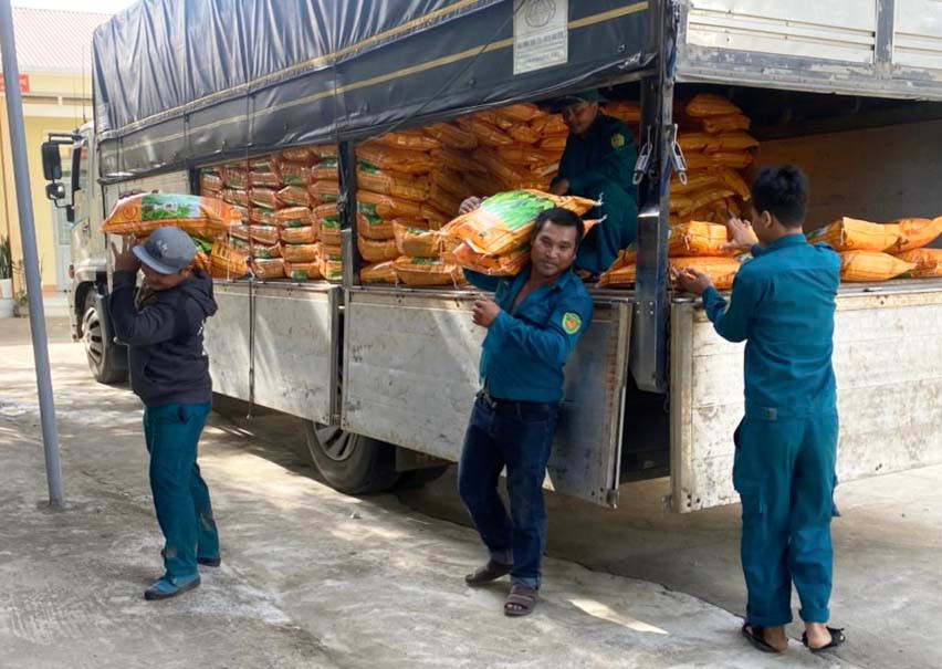 Lực lượng Dân quân xã Ia Broăi hỗ trợ việc tiếp nhận giống lúa. Ảnh: Mai Linh