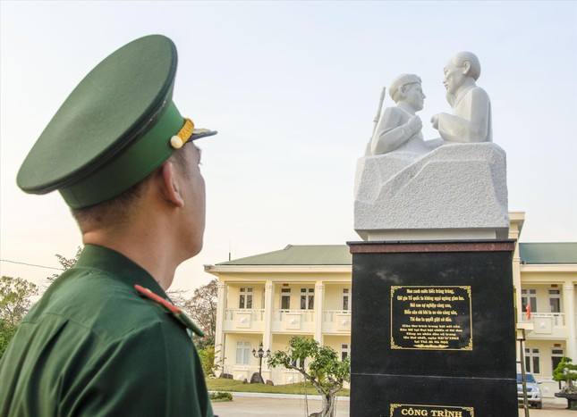 Thiếu tá Bùi Huy Triệu bên tượng đài Bác Hồ với chiến sĩ biên phòng bằng đá hoa cương ở Đồn Biên phòng Đắk Đam. Ảnh: Văn Chương