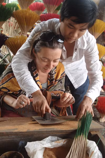 Du khách quốc tế thích thú khi được người dân làng hương Dương Xuân Thượng (TP. Huế) trực tiếp hướng dẫn cách làm ra cây hương truyền thống. Ảnh: Bùi Oanh 