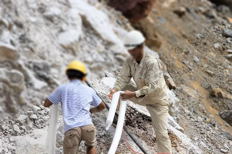 Những thợ đá nhồi từng túi thuốc nổ lớn vào để chuẩn bị phá núi.
