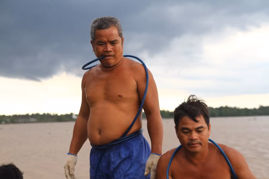 Ông Tùng lặn (phải) có gần 32 năm làm nghề lặn sông. Ông Tùng lặn (phải) có gần 32 năm làm nghề lặn sông.