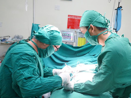 Các bác sĩ phẫu thuật đặt thanh kim loại nâng ngực cho bệnh nhân.