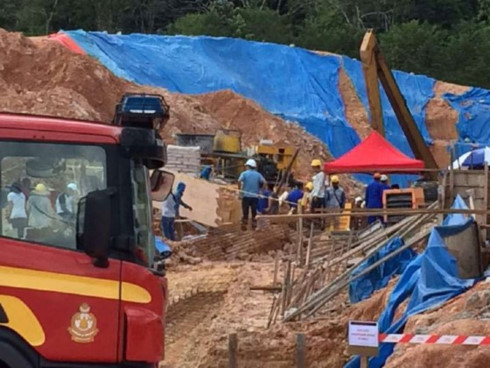 Lính cứu hỏa và công nhân tìm kiếm người mắc kẹt trong vụ lở đất tại công trường xây dựng ở Tanjung Bungah, Penang, Malaysia, ngày 21-10-2107.