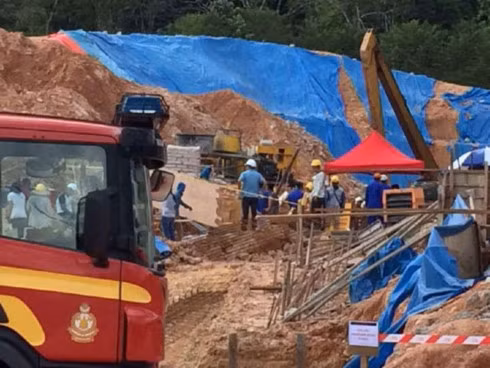 Lính cứu hỏa và công nhân tìm kiếm người mắc kẹt trong vụ lở đất tại công trường xây dựng ở Tanjung Bungah, Penang, Malaysia, ngày 21-10-2107.