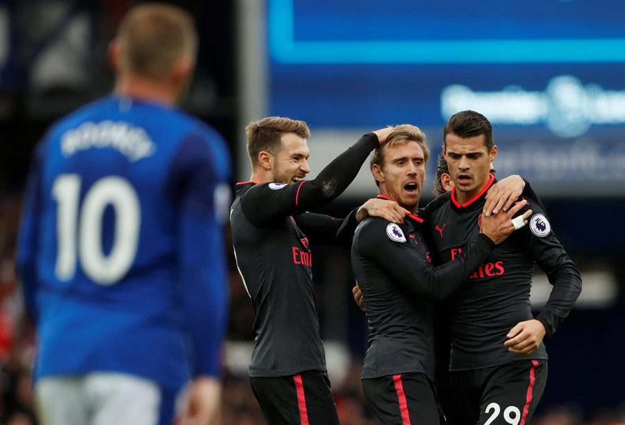Niềm vui của các cầu thủ Arsenal sau khi Monreal gỡ hòa 1-1. Ảnh: REUTERS Rooney (trái) ăn mừng bàn mở tỉ số cho Everton. Ảnh: GETTY IMAGES