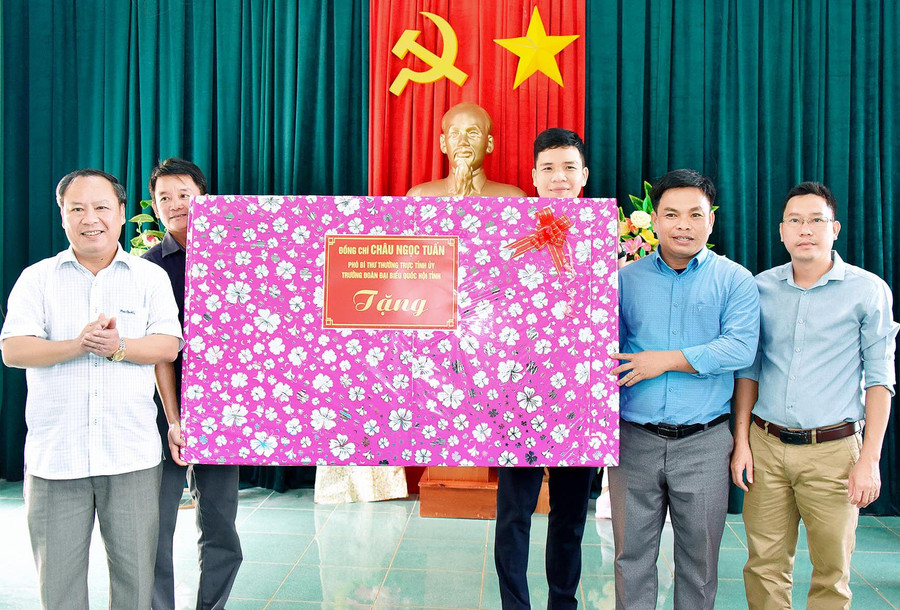 Phó Bí thư Thường trực Tỉnh ủy, Trưởng đoàn đại biểu Quốc hội tỉnh Châu Ngọc Tuấn (bìa trái) tặng quà cho hệ thống chính trị xã Đak Trôi, huyện Mang Yang. Ảnh: Đức Thụy