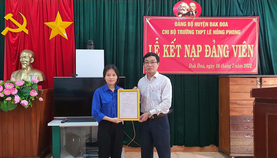 Bí thư Chi bộ, Hiệu trưởng Trường THPT Lê Hồng Phong Võ Tiến Tùng (phải) trao quyết định kết nạp đảng viên cho Đoàn viên thanh niên ưu tú là học sinh vinh của Trường. Ảnh: Thanh Nhật