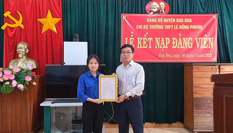 Bí thư Chi bộ, Hiệu trưởng Trường THPT Lê Hồng Phong Võ Tiến Tùng (phải) trao quyết định kết nạp đảng viên cho Đoàn viên thanh niên ưu tú là học sinh vinh của Trường. Ảnh: Thanh Nhật