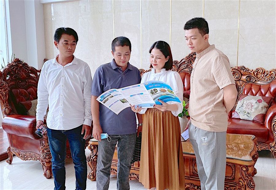 Nhân viên Khách sạn Hoài Thương (thứ hai từ phải sang) hỗ trợ tư vấn, hướng dẫn cho khách lưu trú về những địa điểm vui chơi, ẩm thực tại TP. Pleiku thông qua tờ rơi cẩm nang tự in sẵn. Ảnh: Mộc Trà