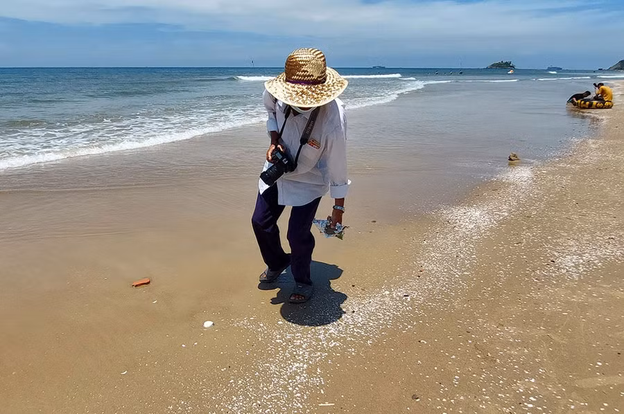 Một thợ ảnh thường xuyên nhặt mảnh chai, vật nhọn tại khu vực Bãi Sau, vì lo ngại du khách đạp trúng