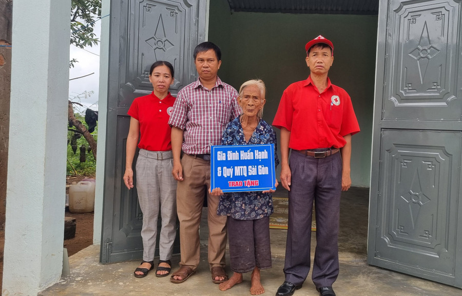 Ông Nguyễn Phấn Tiến-Chủ tịch Hội Chữ thập đỏ huyện Chư Sê (bên phải) trao nhà tình thương cho gia đình bà Rmah HĐom tại làng Ring. Ảnh: Hà Phương