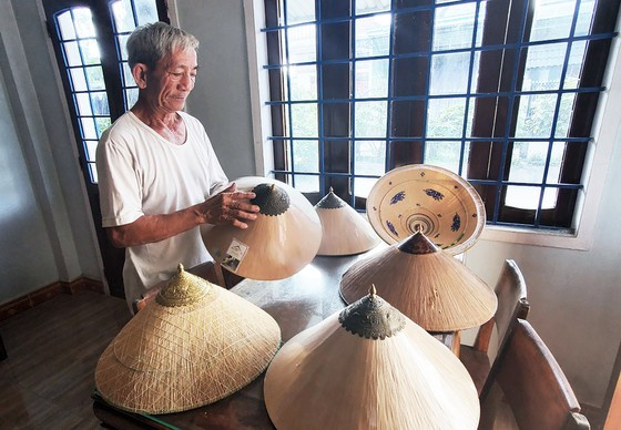 Nghệ nhân Đỗ Văn Lan bên những chiếc nón ngựa thượng hạng, độc đáo nhất của làng Phú Gia. Ảnh: NGỌC OAI